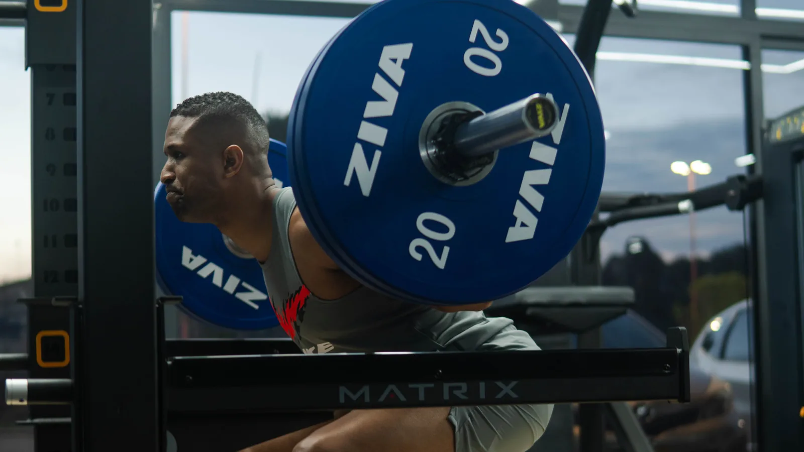 Athlete under a loaded barbell in the strength area